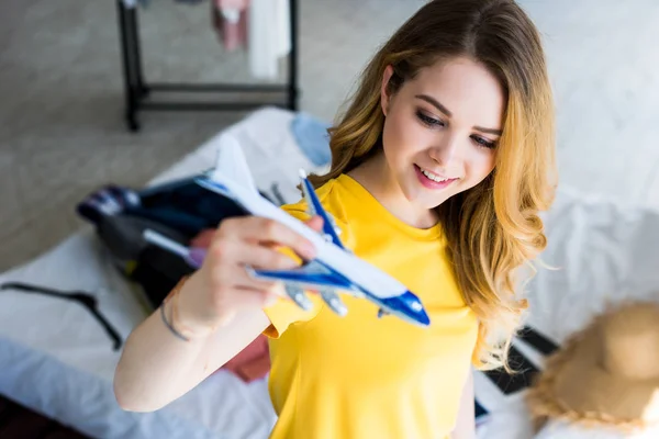 Beautiful young woman with airplane model — Stock Photo