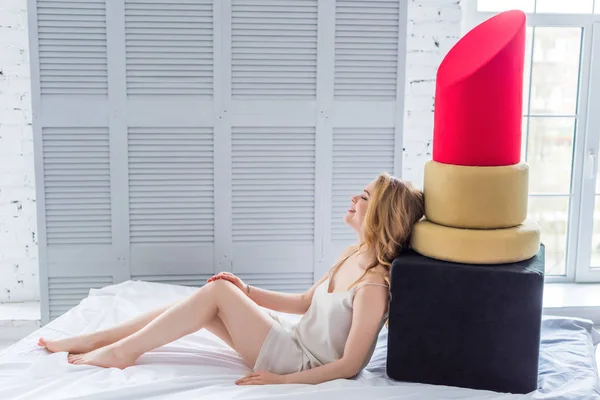 Bella bionda giovane donna in posa con grande rossetto rosso in camera da letto — Foto stock