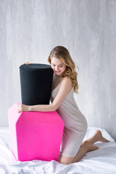 Beautiful girl posing with big pink nail polish on bed — Stock Photo