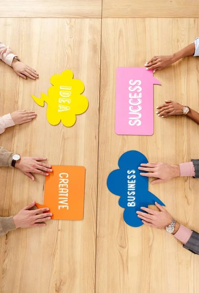 Overhead-Ansicht von multirassischen Geschäftsleuten am Holztisch mit bunten Chat-Blasen mit Erfolg, Idee, Kreativität, Geschäftszeichen — Stockfoto