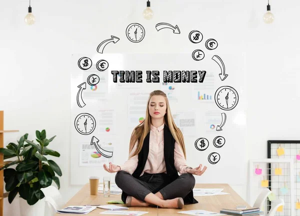 Tranquila mujer de negocios meditando en posición de loto en la mesa en la oficina con tiempo para la inscripción de dinero y dinero y circuito de tiempo - foto de stock