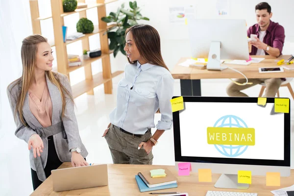 Foco seletivo de mulheres de negócios multiculturais usando laptop juntos no local de trabalho no escritório, ícone webinar na tela do computador — Fotografia de Stock