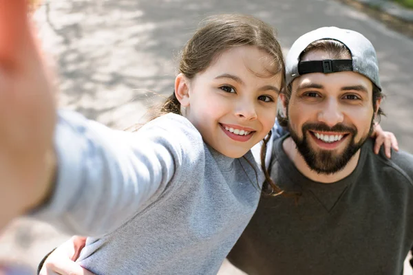 Figlia prendendo selfie sorridente padre nel parco — Foto stock