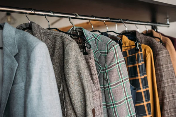 Different jackets on hangers at sewing workshop — Stock Photo