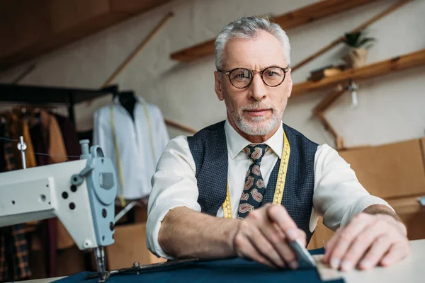 Cheveux gris dessin de tailleur contour sur tissu à l'atelier de couture — Photo de stock