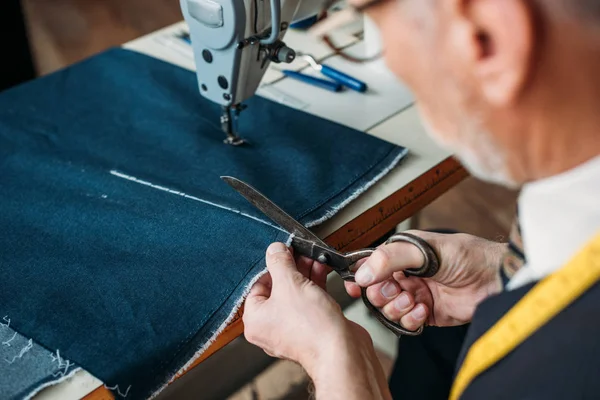 Image recadrée de tissu de coupe de tailleur senior à l'atelier de couture — Photo de stock