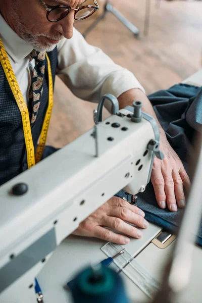 Beau tissu de couture de tailleur professionnel avec machine à coudre à l'atelier de couture — Photo de stock