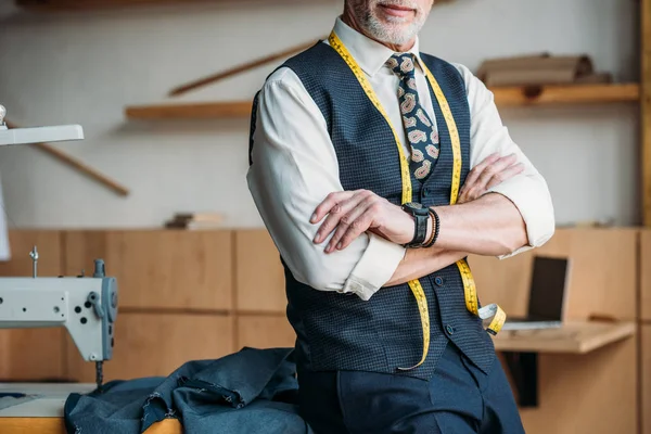 Cropped image of tailor standing with crossed arms at sewing workshop — Stock Photo