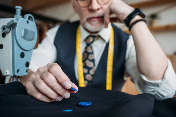 Immagine ritagliata del sarto senior che sceglie i pulsanti al laboratorio di cucito — Foto stock