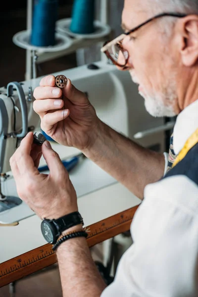 Concentrated mature tailor working with sewing machine at workshop — Stock Photo