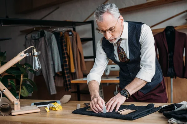 Stilvolle Schneiderzeichnung von Stoffmustern mit Kreide bei Nähwerkstatt — Stockfoto