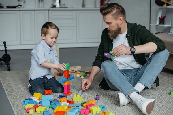 Familie spielt zu Hause mit bunten Bauklötzen — Stockfoto