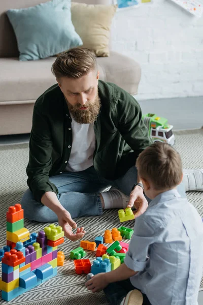 Familie spielt zu Hause mit bunten Bauklötzen — Stock Photo