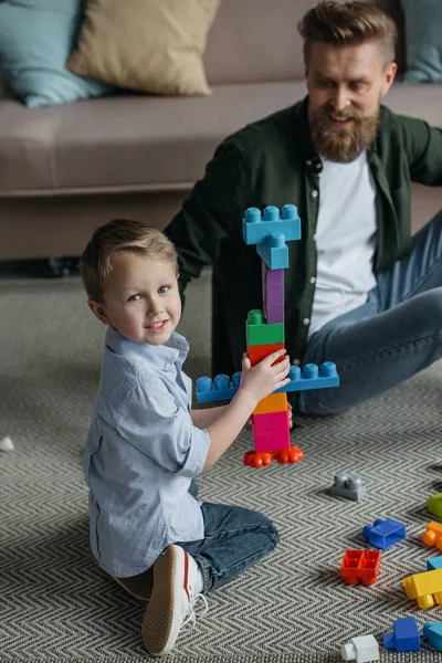 Família brincando com blocos coloridos juntos em casa — Fotografia de Stock