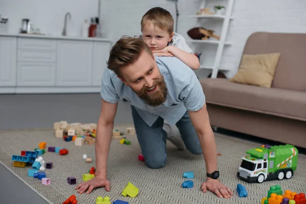 Lächelnder Vater und kleiner Sohn amüsieren sich gemeinsam zu Hause — Stockfoto
