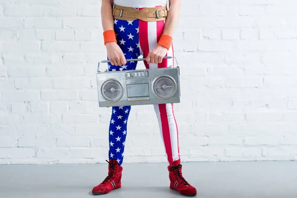 Cropped shot of senior woman in patriotic sportswear holding tape recorder — Stock Photo