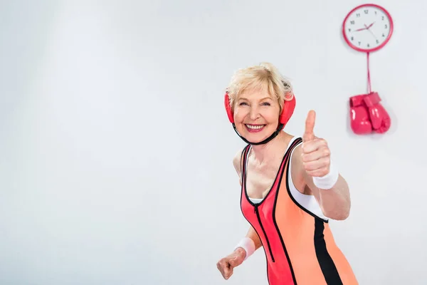 Fröhliche Seniorin zeigt Daumen hoch und lächelt in die Kamera — Stockfoto