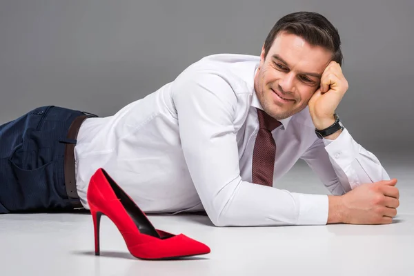 Homme d'affaires souriant regardant la colline rouge femelle, isolé sur gris, concept de féminisme — Photo de stock
