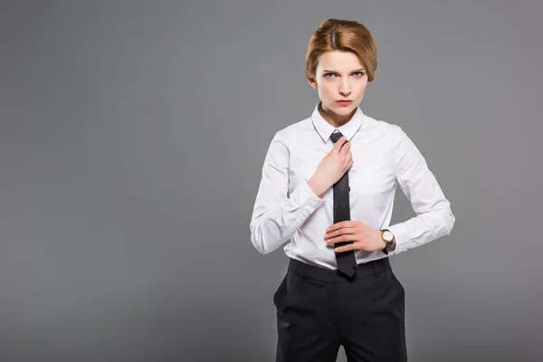 Confident businesswoman in white shirt and tie, isolated on grey — Stock Photo