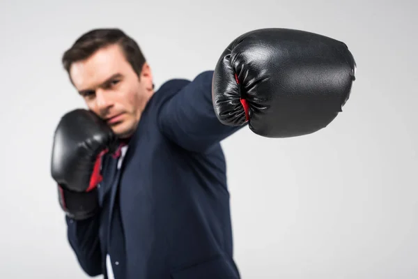 Foco seletivo do homem sério em luvas de boxe, isolado em cinza — Fotografia de Stock