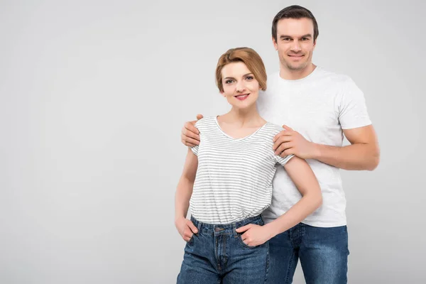 Sonriente marido abrazando a su esposa, aislado en gris - foto de stock