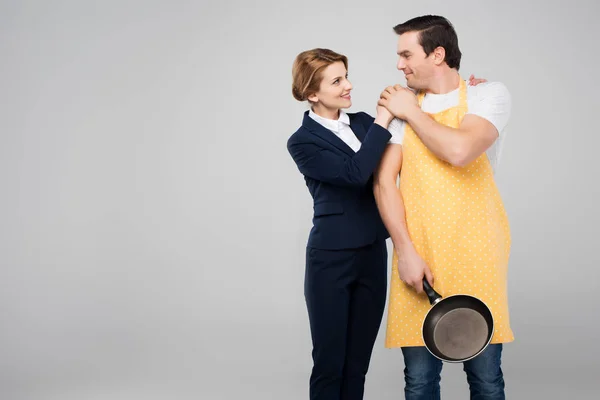 Businesswoman and male householder hugging together, feminism concept, isolated on grey — Stock Photo