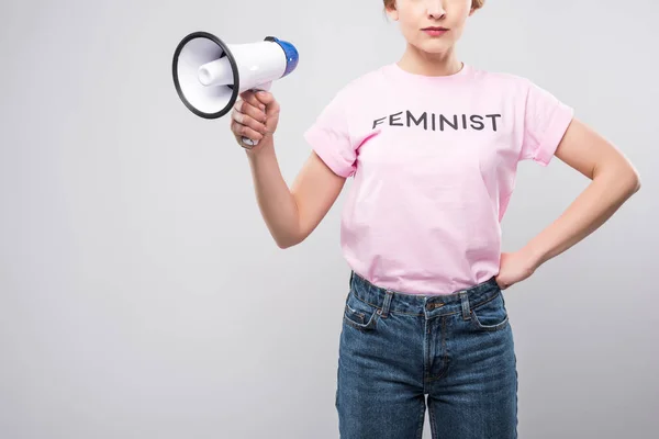 Vista recortada de la mujer en camiseta feminista rosa sosteniendo megáfono, aislado en gris - foto de stock