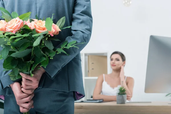 Businessman holding roses for colleague — Stock Photo, Image