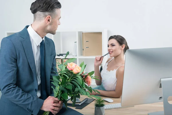 Empresário apresentando rosas a colega no local de trabalho — Fotografia de Stock