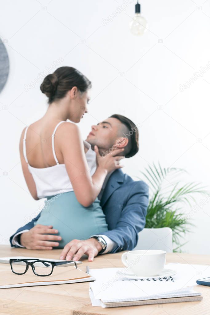 businesspeople hugging in foreplay at workplace