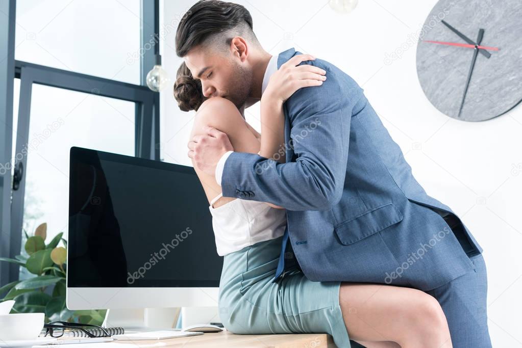 business colleagues kissing in foreplay at workplace