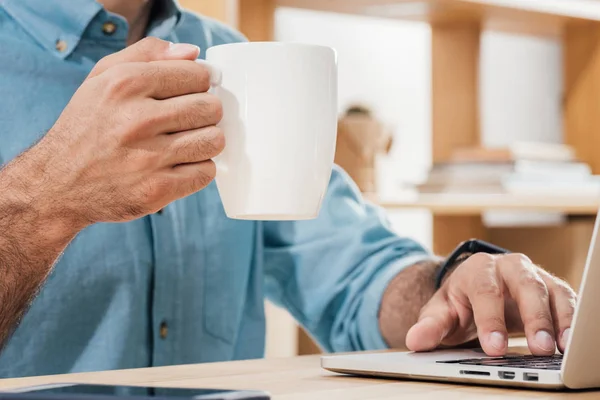 Hombre de negocios con taza de café en el lugar de trabajo — Foto de Stock