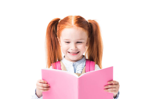 Улыбающаяся школьница читает учебник
