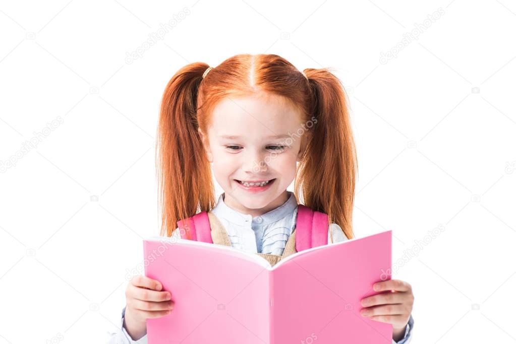 Smiling schoolgirl reading textbook