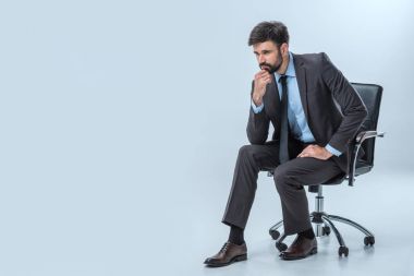 pensive businessman sitting on chair