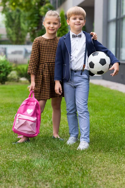 Школьники с рюкзаком и футбольным мячом — стоковое фото