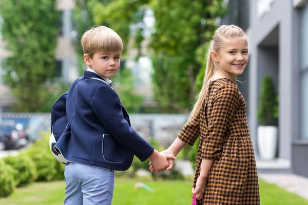 Cute schoolchildren holding hands — Stock Photo, Image