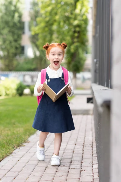 Redhead schoolgirl holding book — Stock Photo, Image
