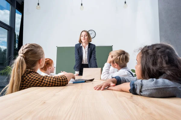 öğrencilere öğretmen açıklayan ders 