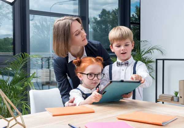 Enseignant avec des écoliers utilisant une tablette numérique — Photo