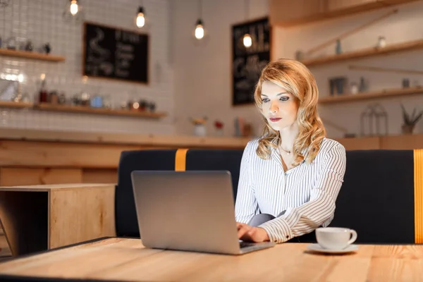 Бізнес-леді використовує ноутбук у кафе — стокове фото