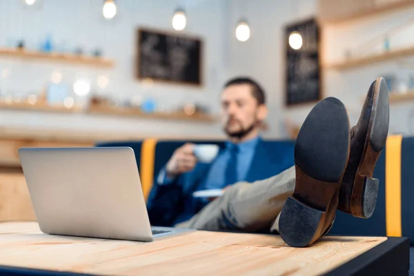 Empresario usando laptop en cafetería —  Fotos de Stock