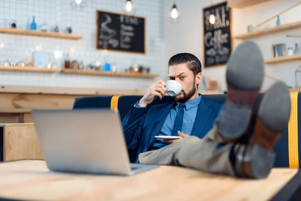 Empresario usando laptop en cafetería — Foto de Stock