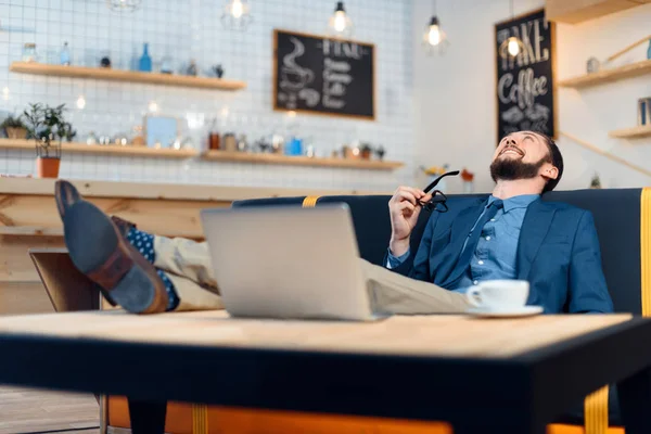 Επιχειρηματίας χρησιμοποιώντας φορητό υπολογιστή στην καφετέρια — Δωρεάν Φωτογραφία
