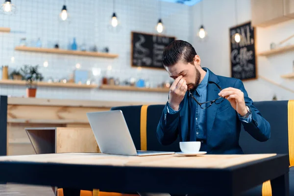 Empresario usando laptop en cafetería — Foto de Stock