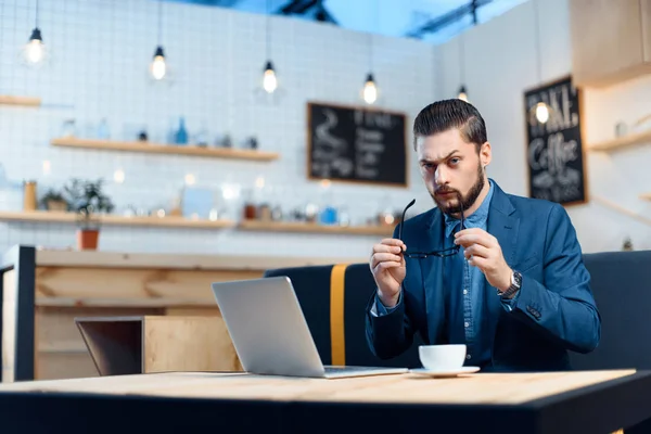 Επιχειρηματίας χρησιμοποιώντας φορητό υπολογιστή στην καφετέρια — Φωτογραφία Αρχείου