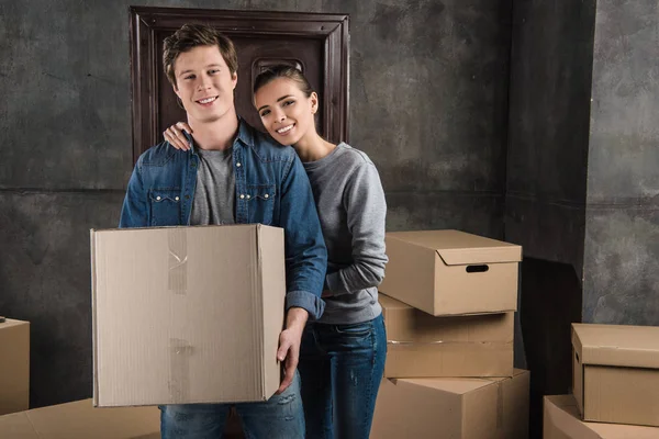 Casal com caixa de papelão em nova casa — Fotografia de Stock