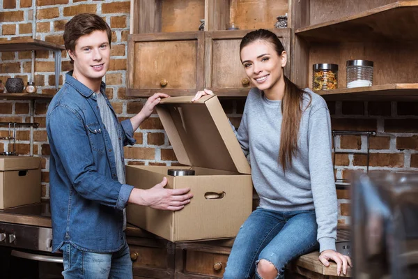 Couple unpacking cardboard box — Stock Photo, Image