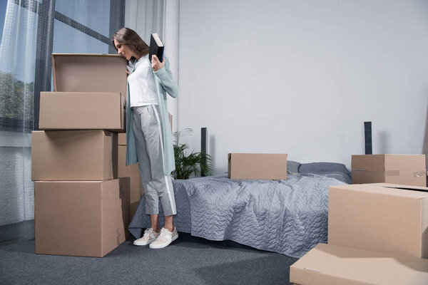 woman unpacking cardboard boxes
