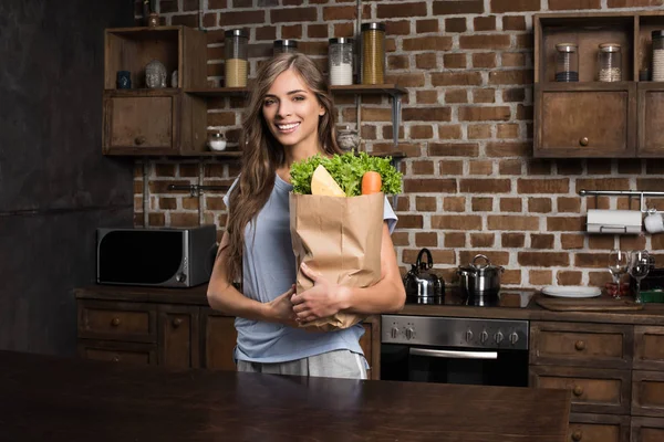 Woman with paper bag full of food — Stock Photo, Image